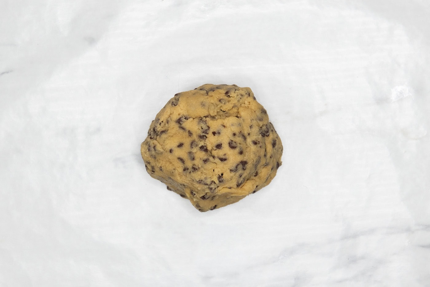 chocolate chip cookie dough ball in parchment paper