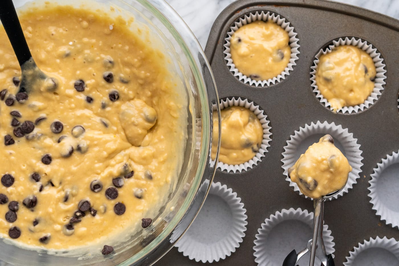 adding batter to muffin pan with liners