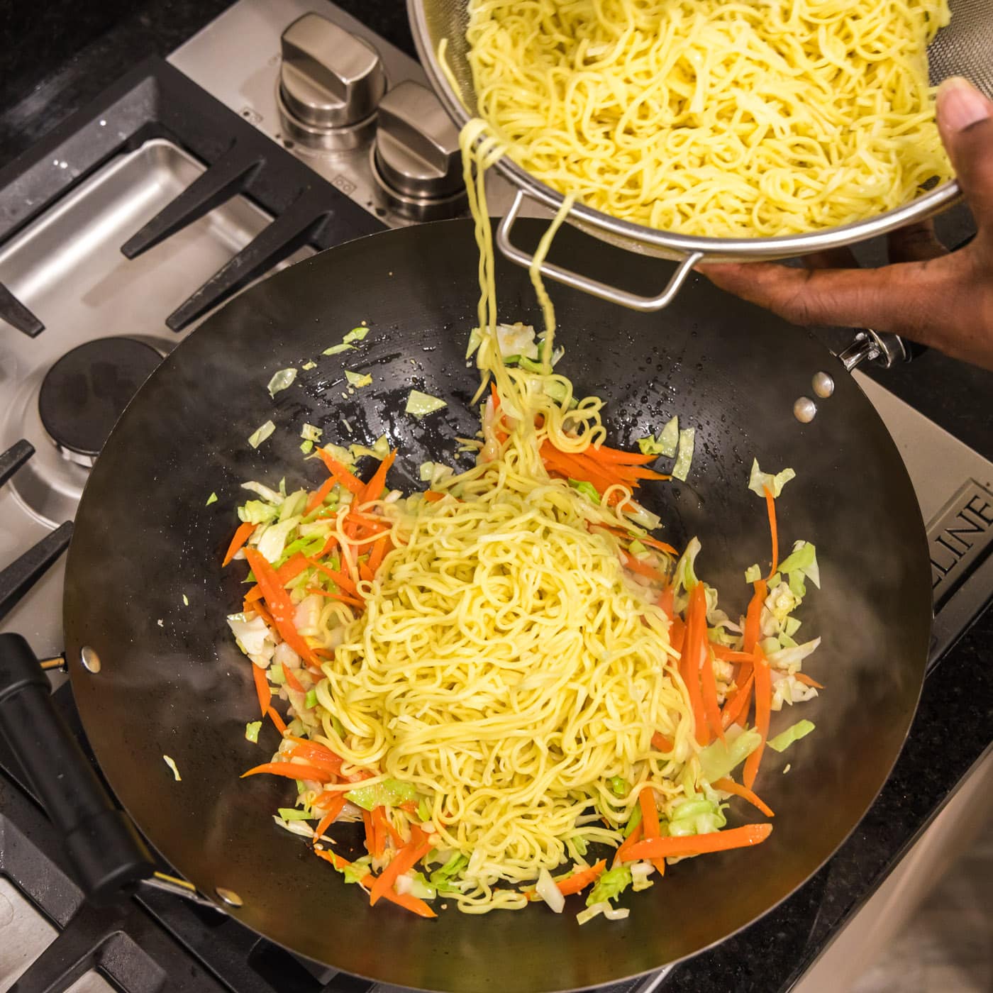 adding cooked noodles to chow mein mixture