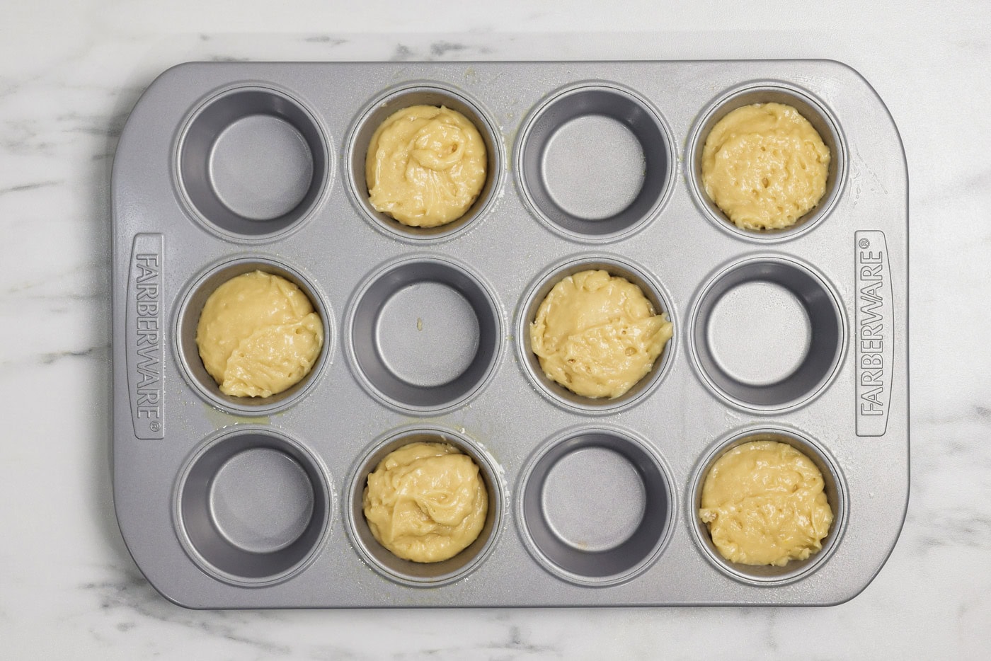 Muffin pan cavities filled with batter