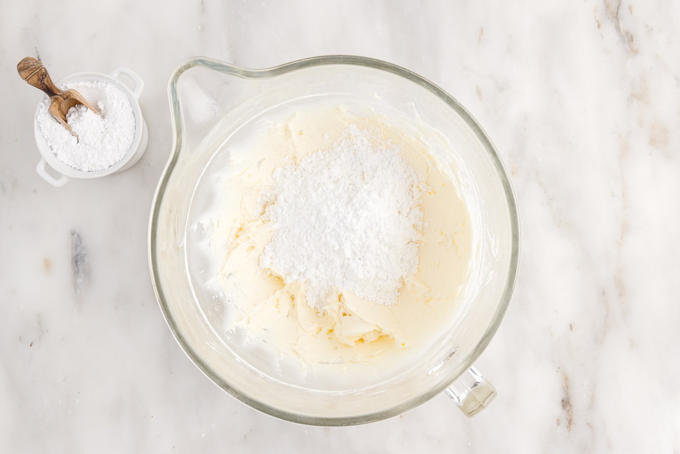 powdered sugar added to cream cheese mixture in a bowl