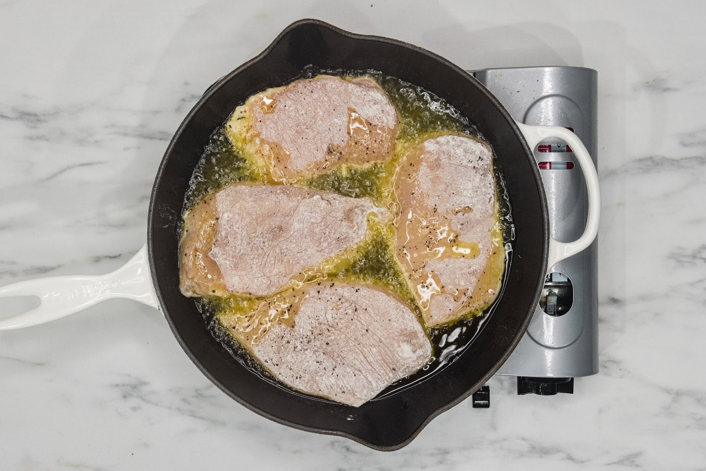 dredged chicken cooking in hot oil