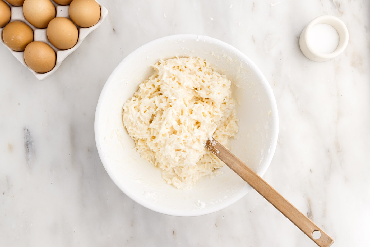 coconut macaroon ingredients in a bowl with rubber spatula