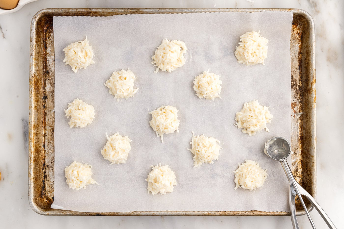 mounds of coconut macaroons on a baking sheet