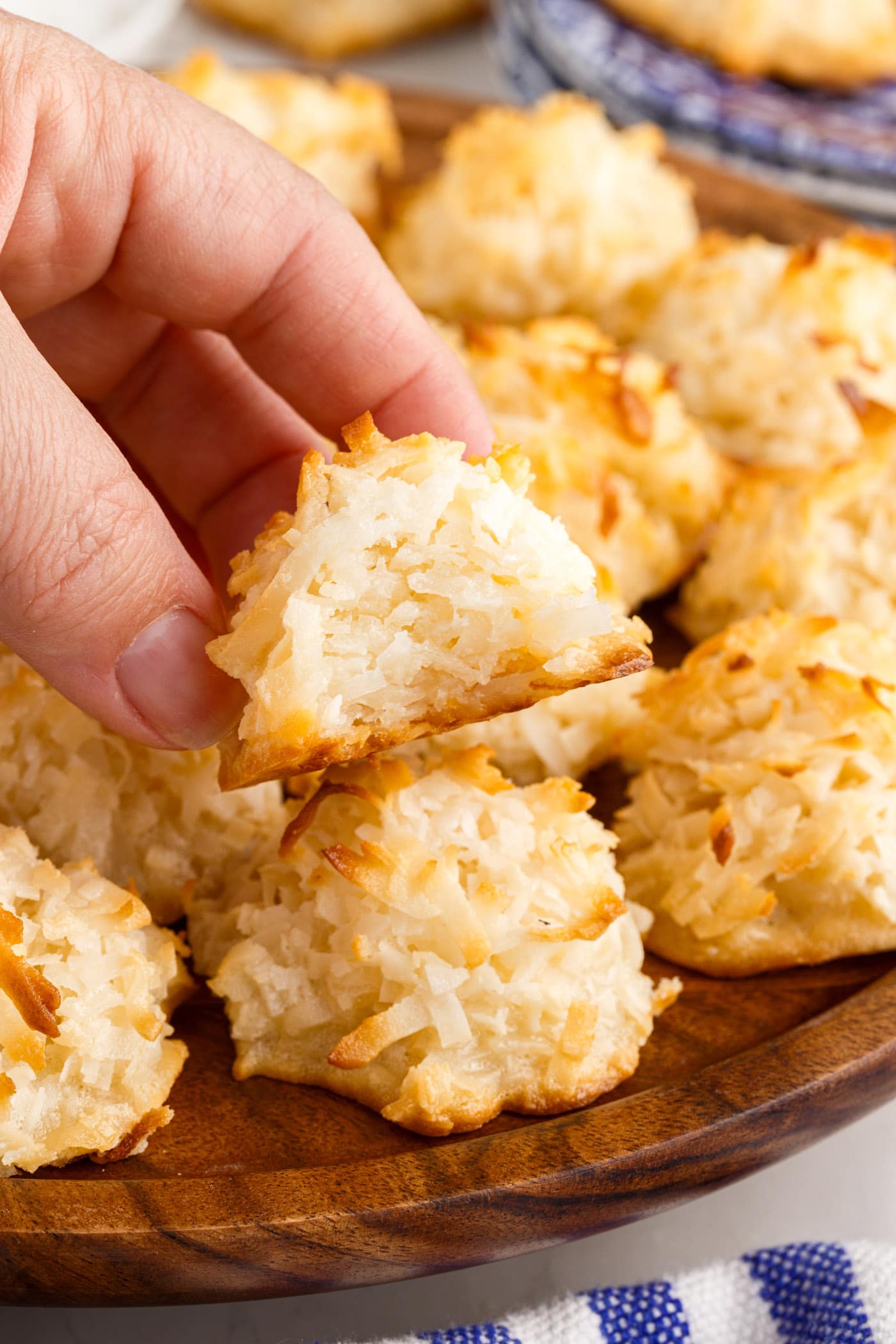 Hand holding a Coconut Macaroon with a bite taken out