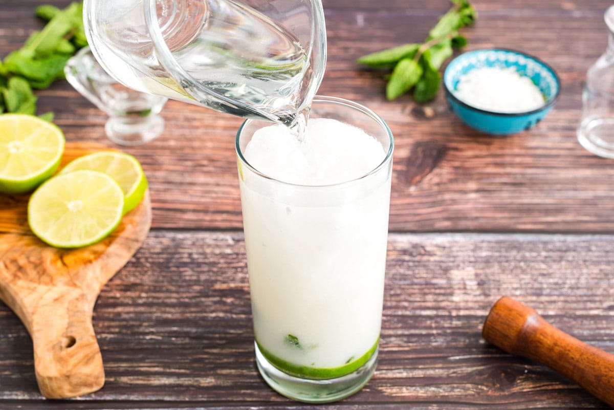 adding club soda to glass