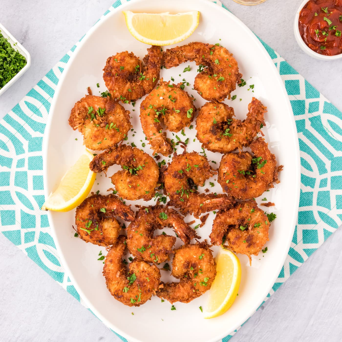 Coconut Shrimp on a platter with lemon wedges