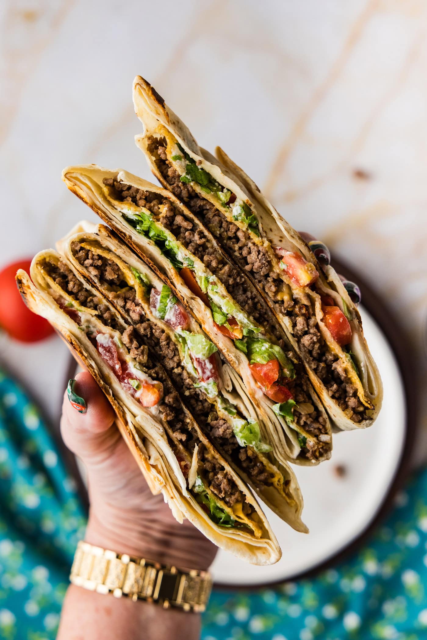 holding sliced Copycat Taco Bell Crunchwrap Supreme