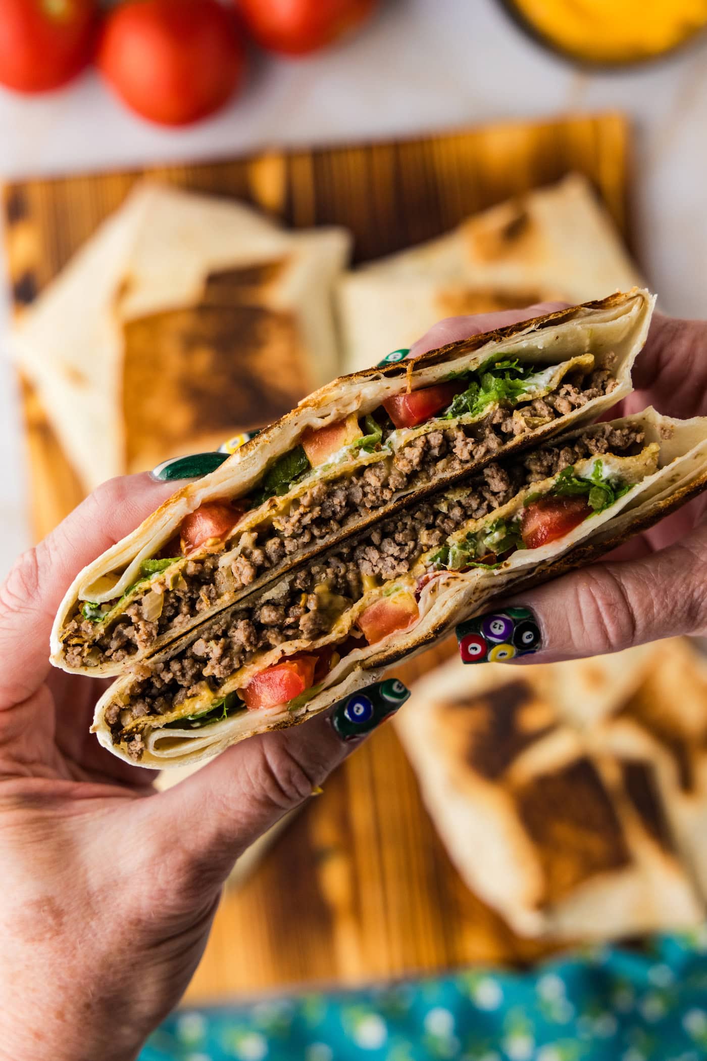 hand holding a cut Copycat Taco Bell Crunchwrap Supreme