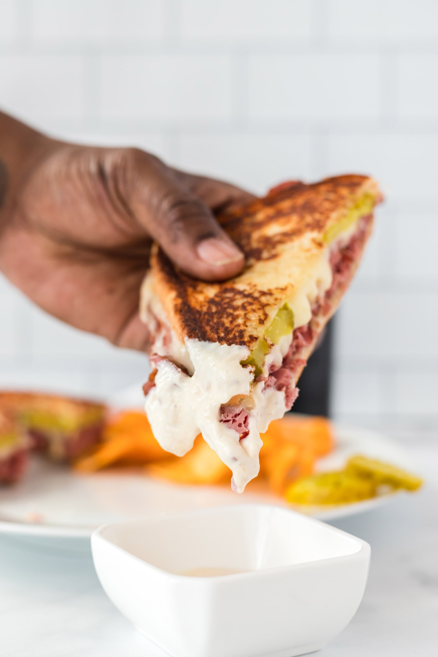 dipping Corned Beef Sandwich in sauce