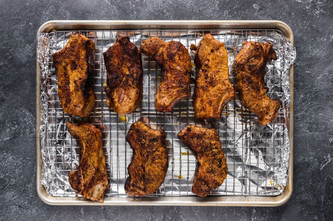 pork ribs on a wire rack over a baking sheet