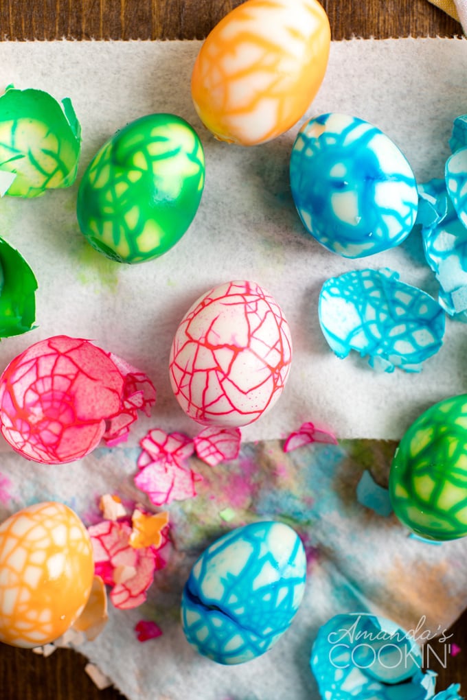 cracked colored eggs with their shells on paper towels