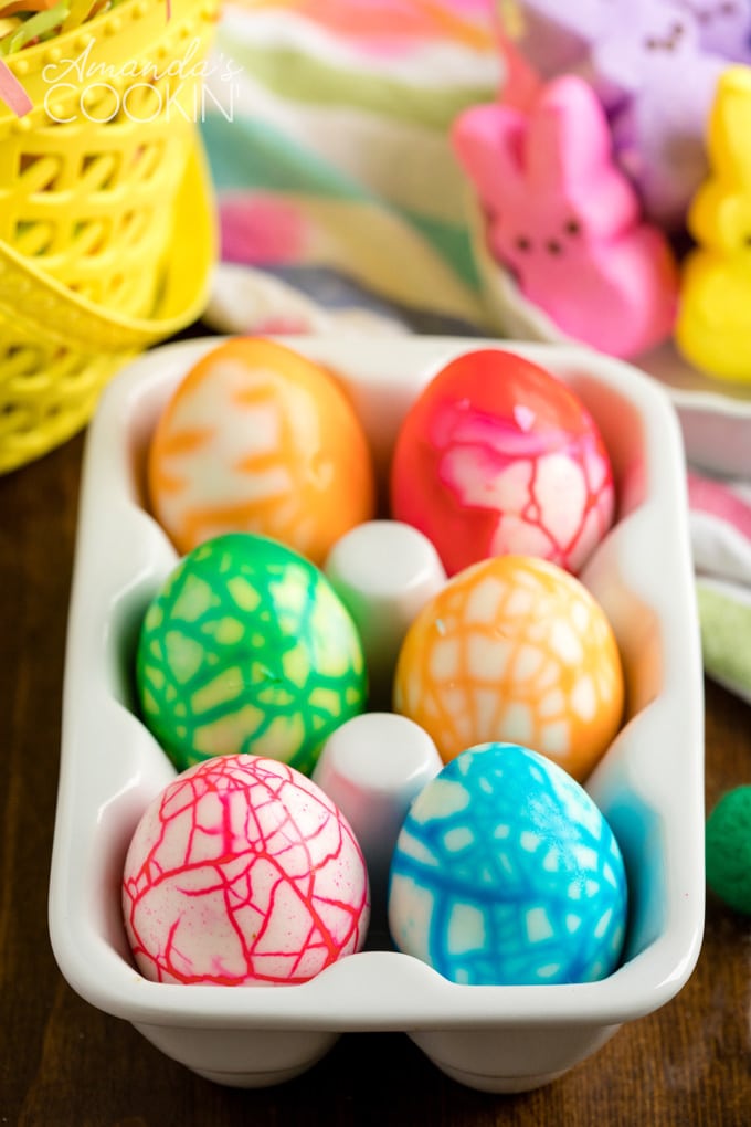 cracked colored eggs in a ceramic egg holder