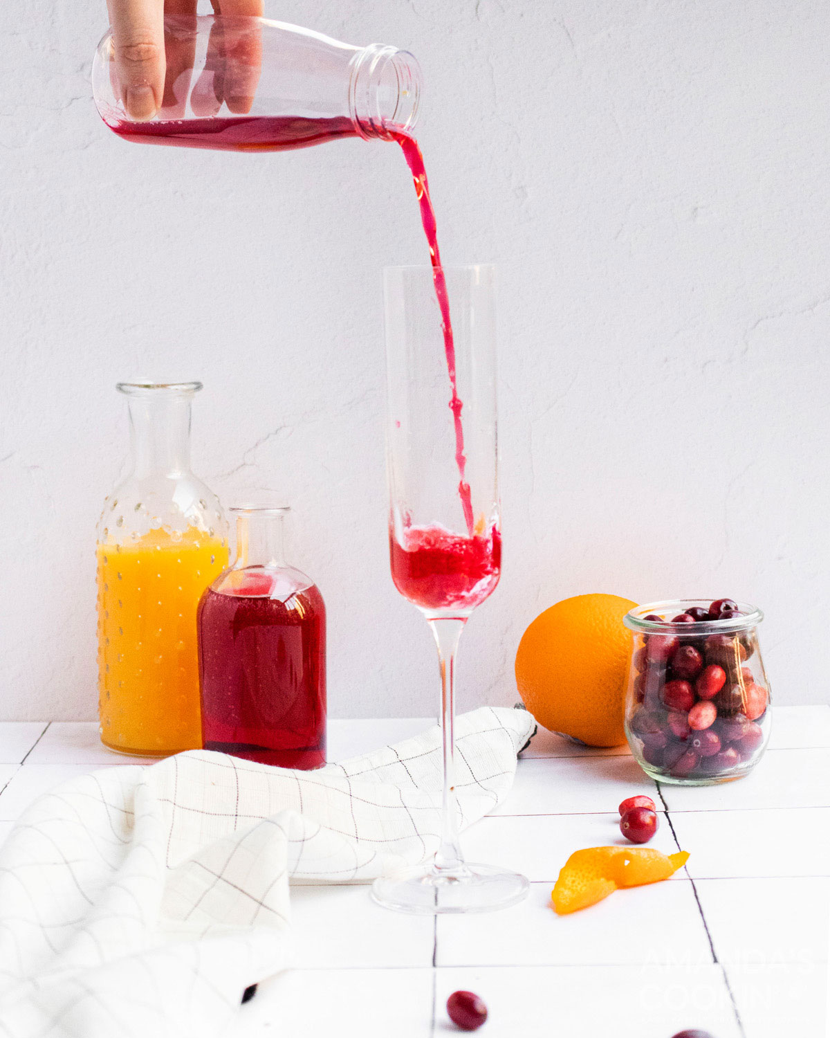 pouring cranberry juice into a chamagne flute
