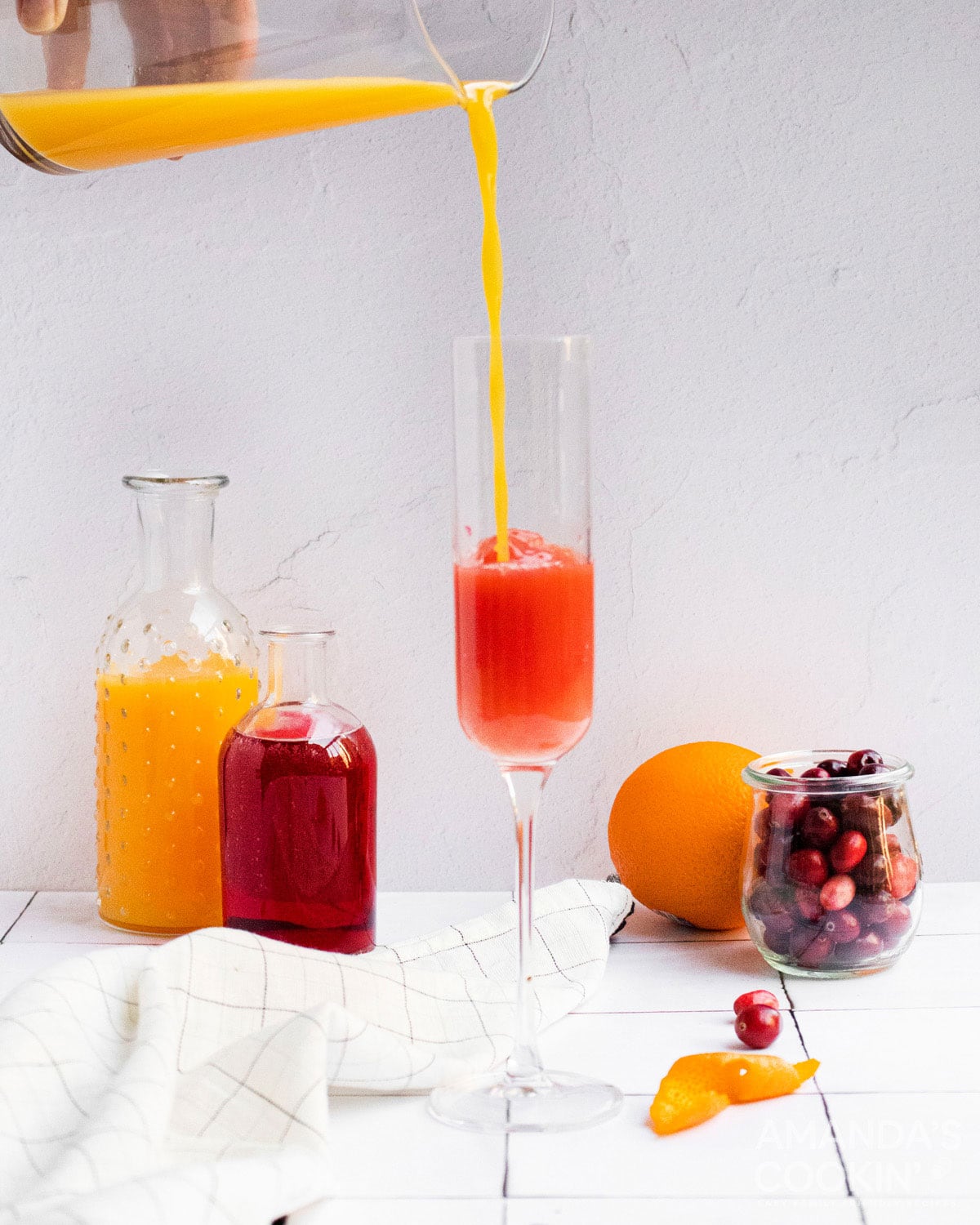pouring orange juice into a chamagne flute