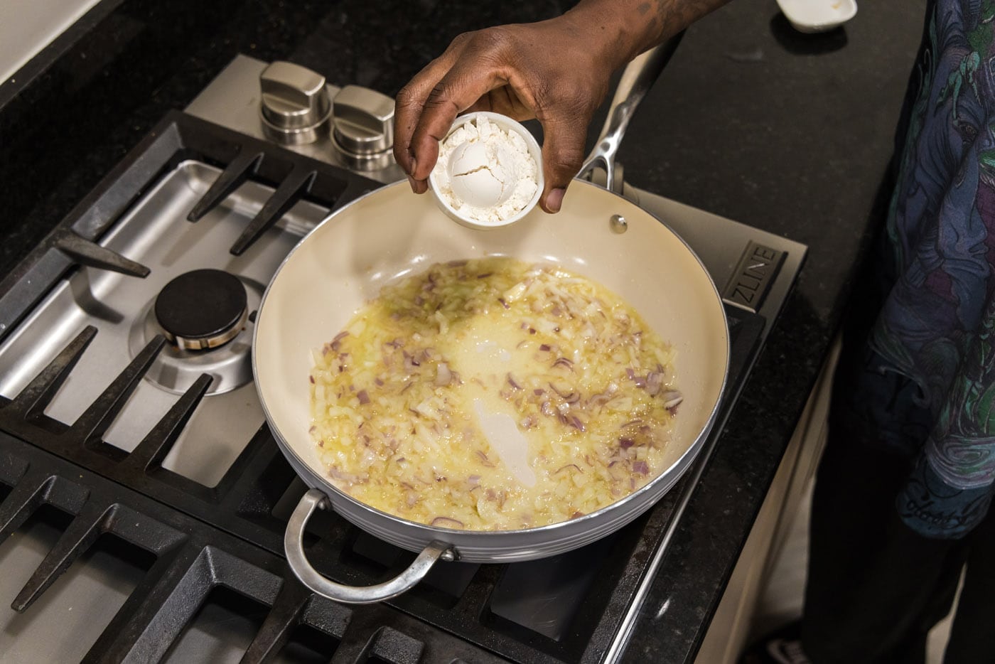 adding flour to skillet to make a roux