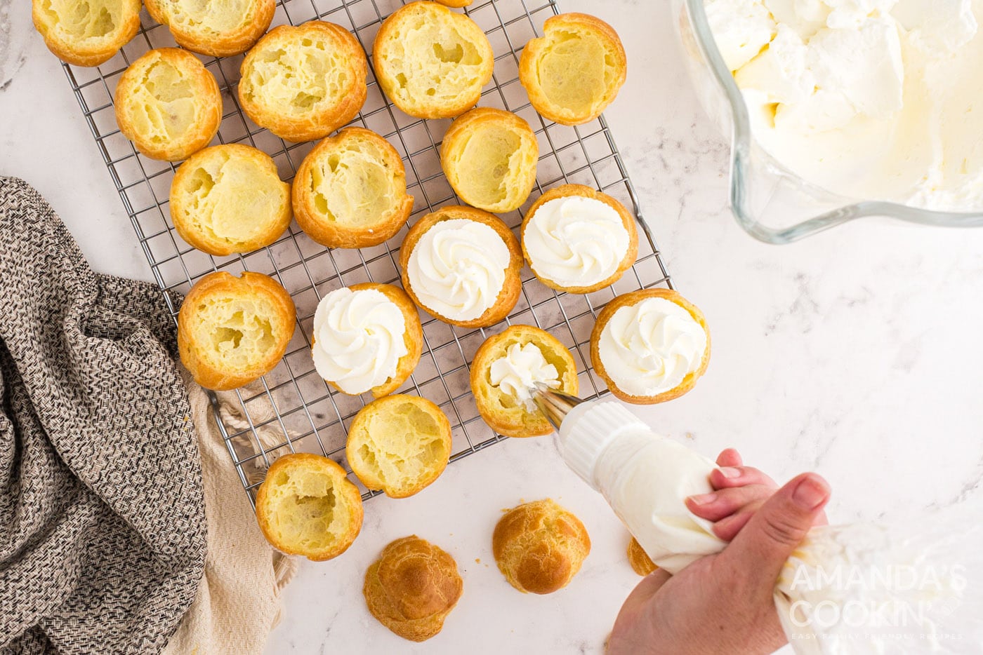 piping whipped cream onto choux pastry dough