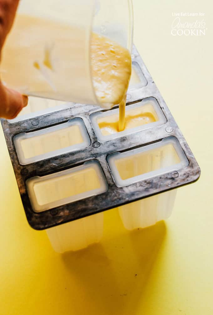Pouring the blended mixture of fruits into the popsicle molds