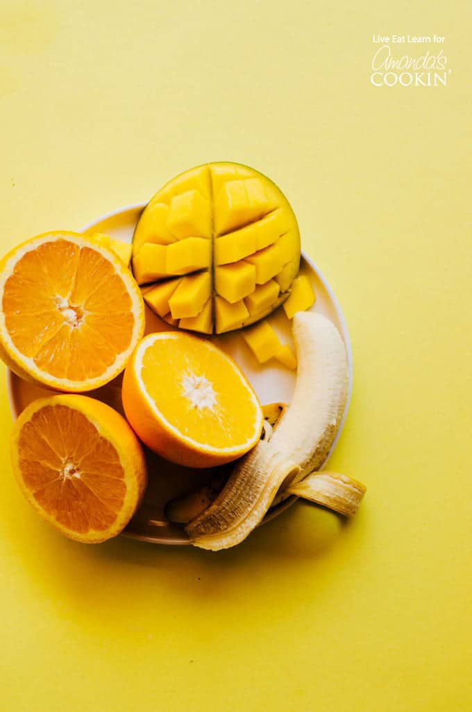 Mango, oranges and bananas on a plate