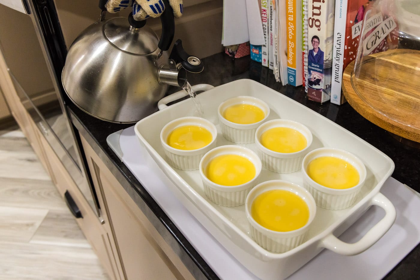 pouring water into baking dish with creme brulee