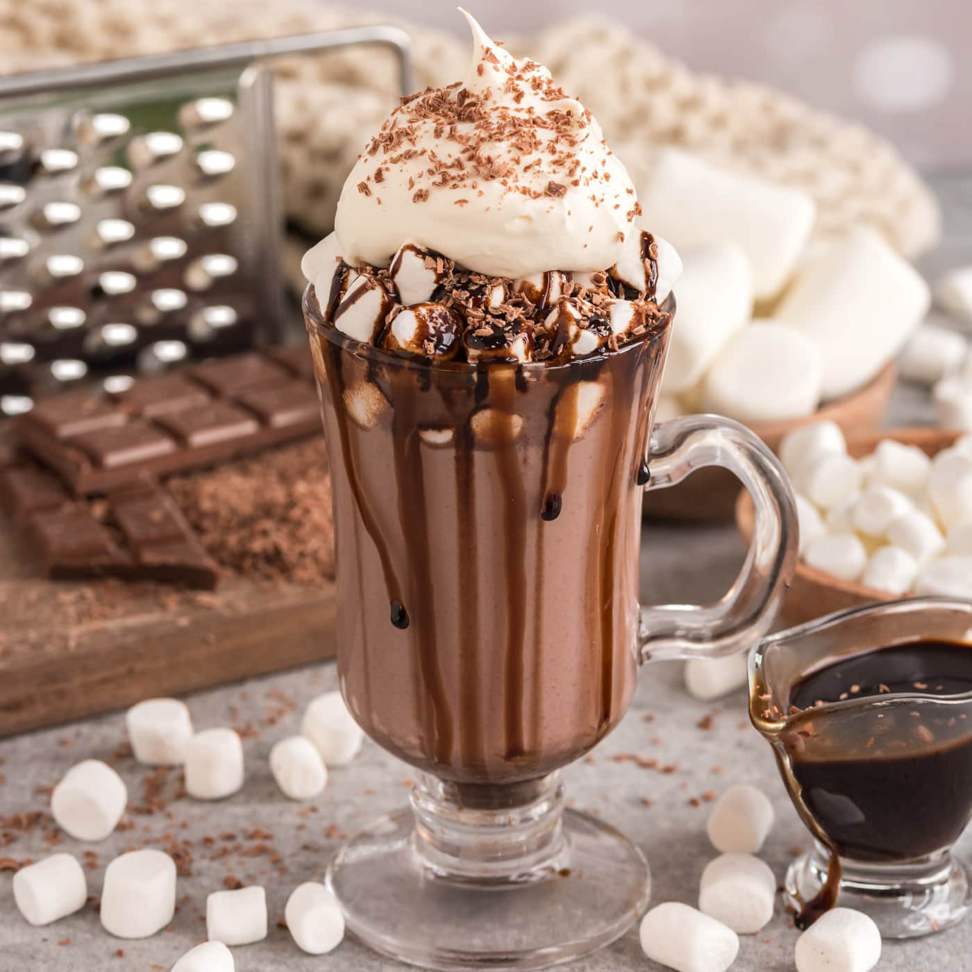 Crockpot Hot Chocolate in a mug topped with chocolate drizzle, whipped cream and chocolate shavings