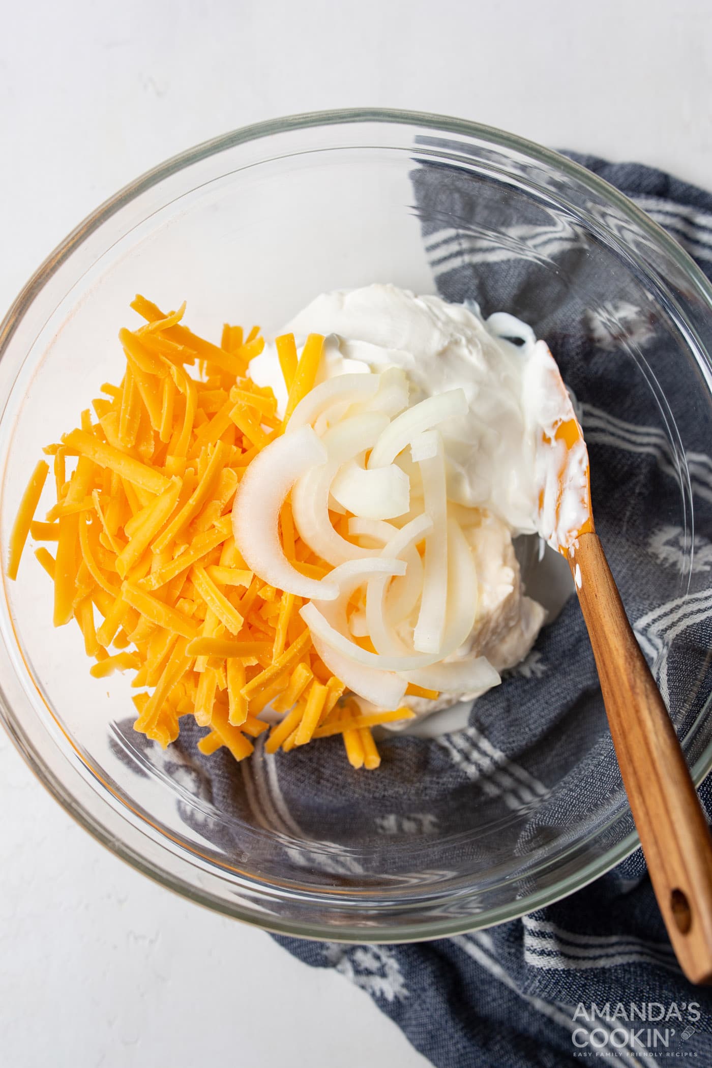 sour cream, mayo, cheese, and onions mixed in a bowl