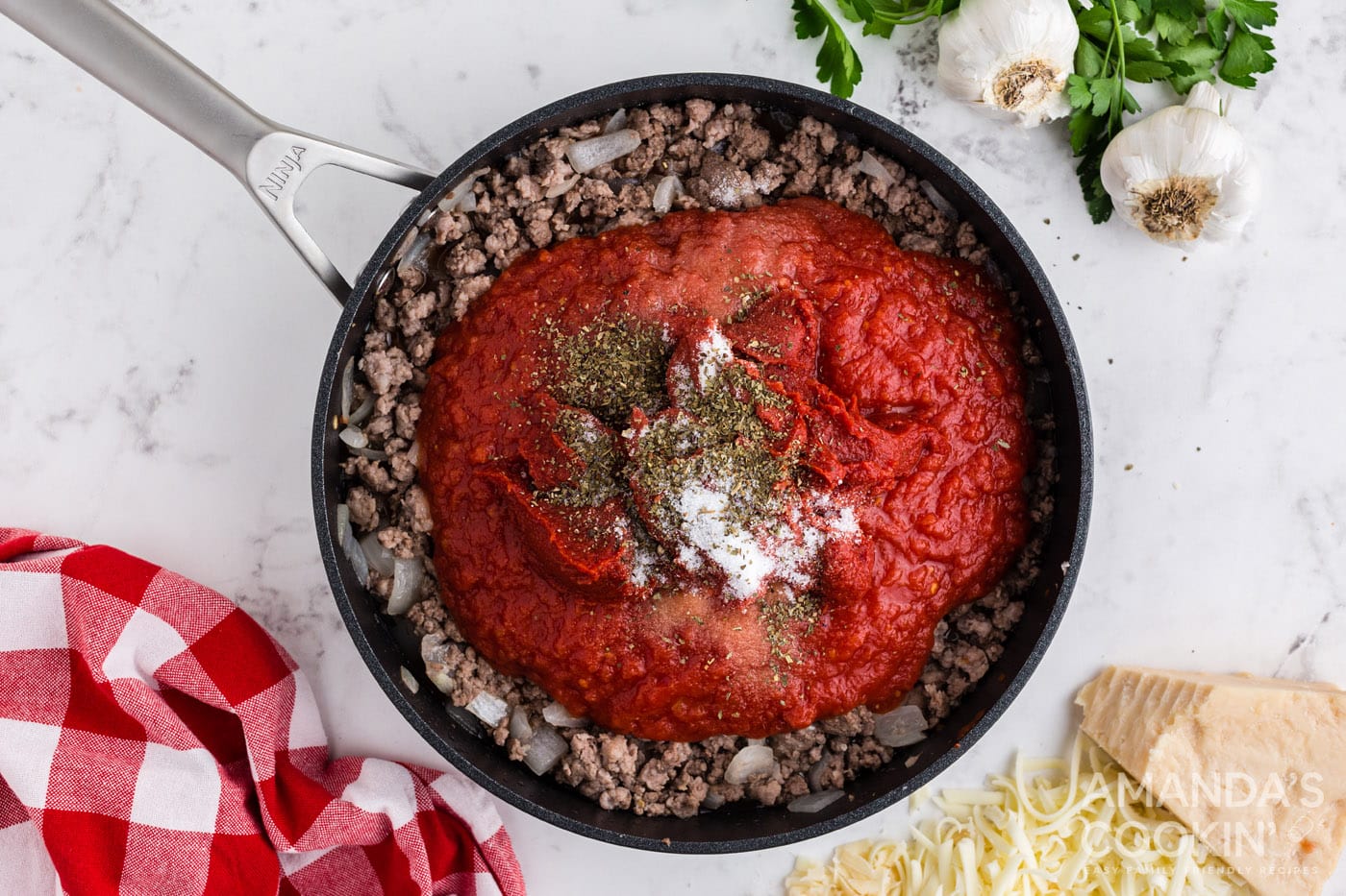 tomato sauce on top of cooked meat in a skillet