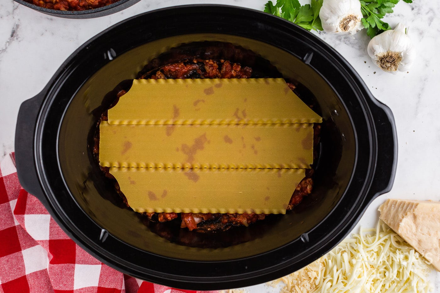 lasagna noodles on top of meat sauce in crockpot