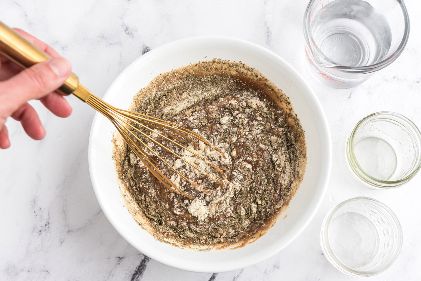whisking gravy, ranch dressing mix, and italian dressing mix in a bowl