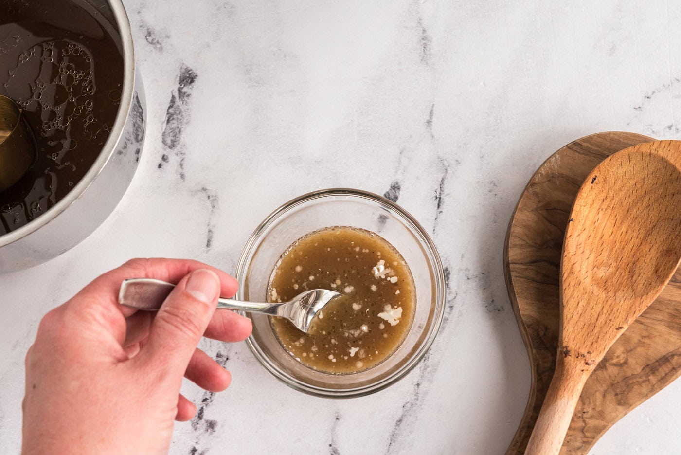 whisking cornstarch with pan juices in a bowl