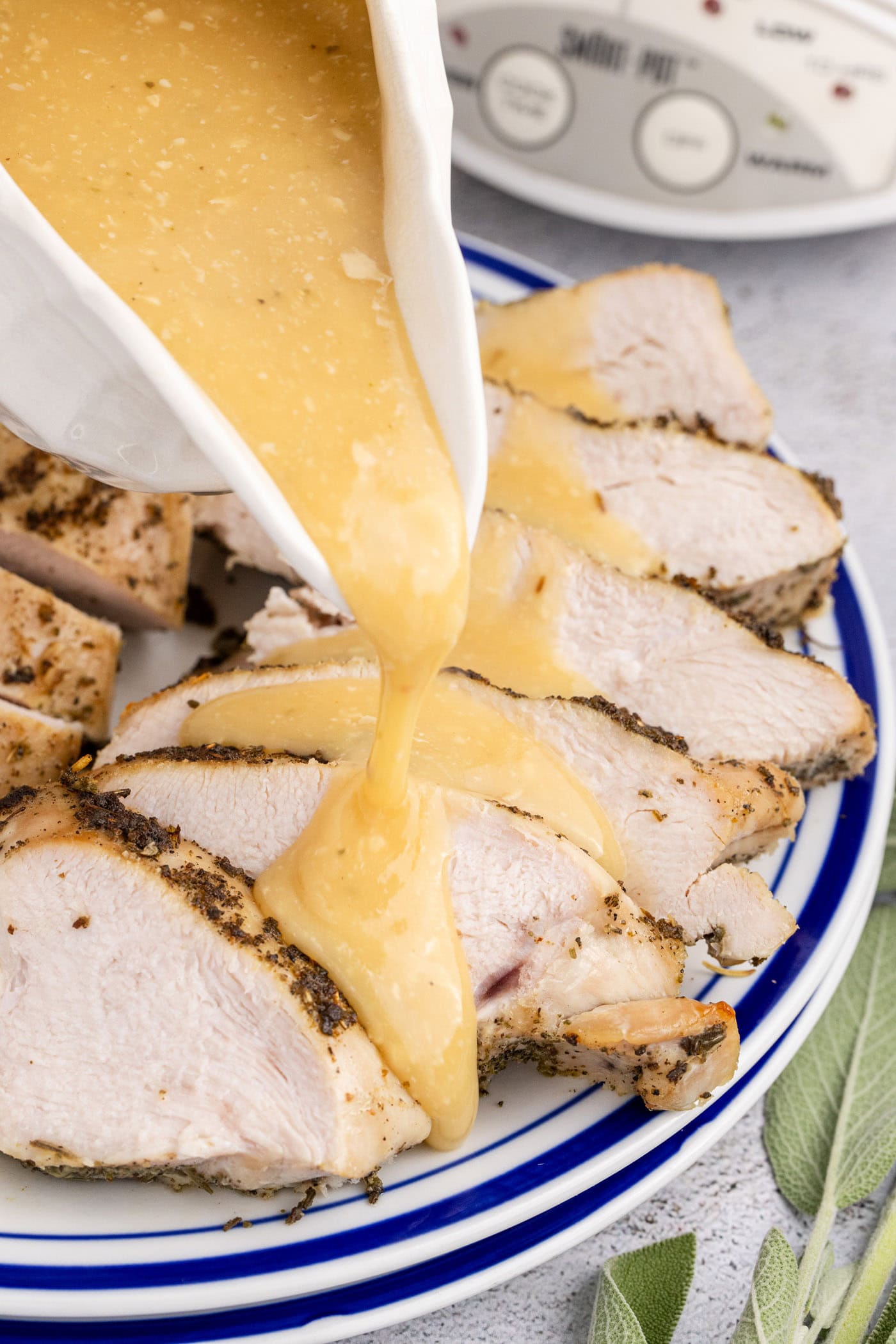 Gravy being poured onto slices of Crockpot Turkey Breast