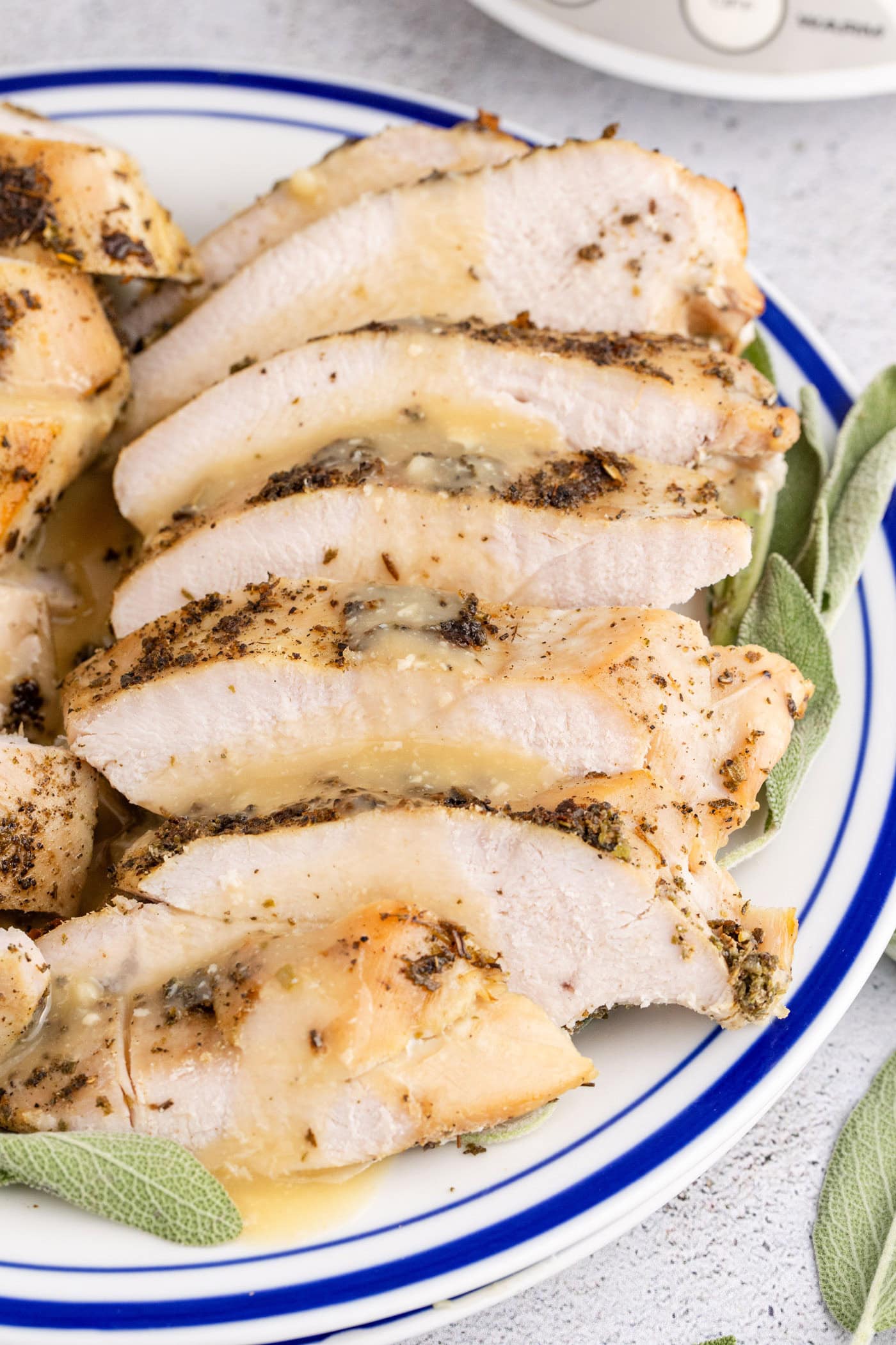 Slices of Crockpot Turkey Breast covered in gravy on a plate