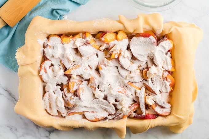 sugar mixture sprinkled over the top of the peaches in pan