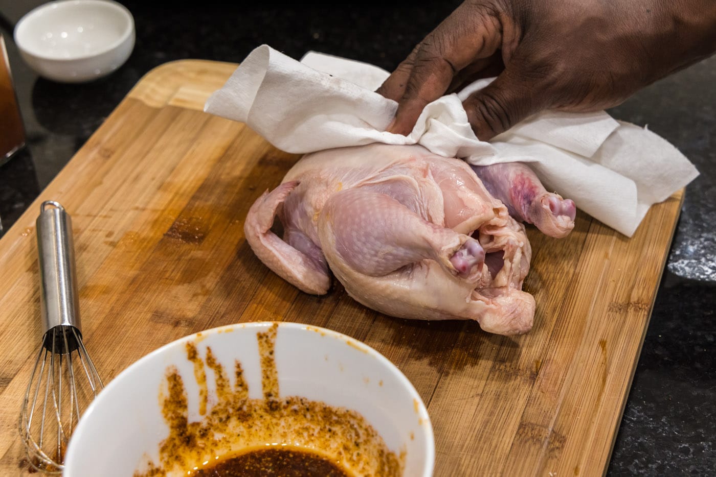 dabbing cornish hen dry with a paper towel