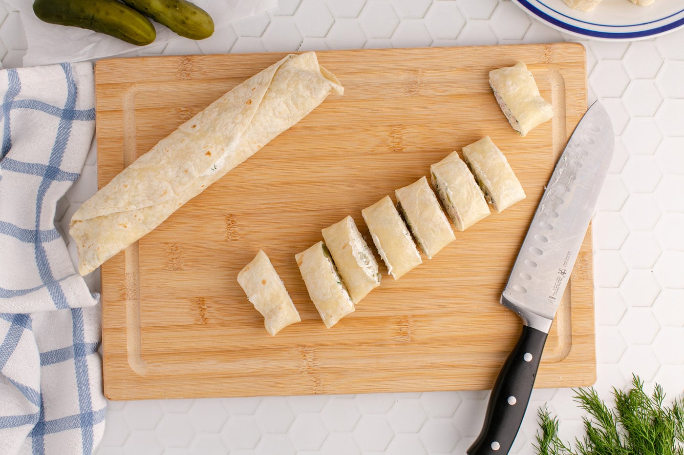 sliced dill pickle pinwheels on a cutting board