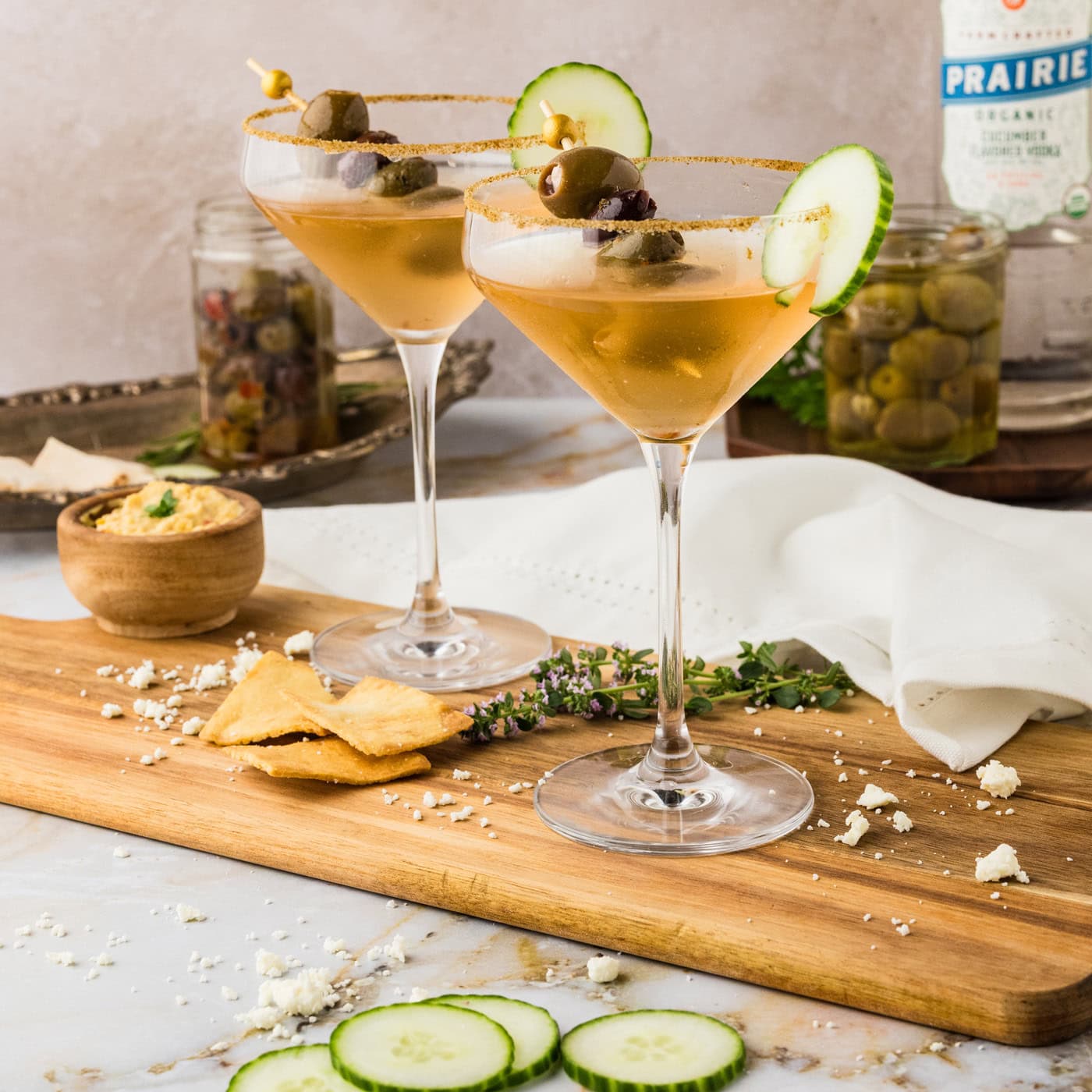 Two Dirty Greek Martinis on a wooden platter
