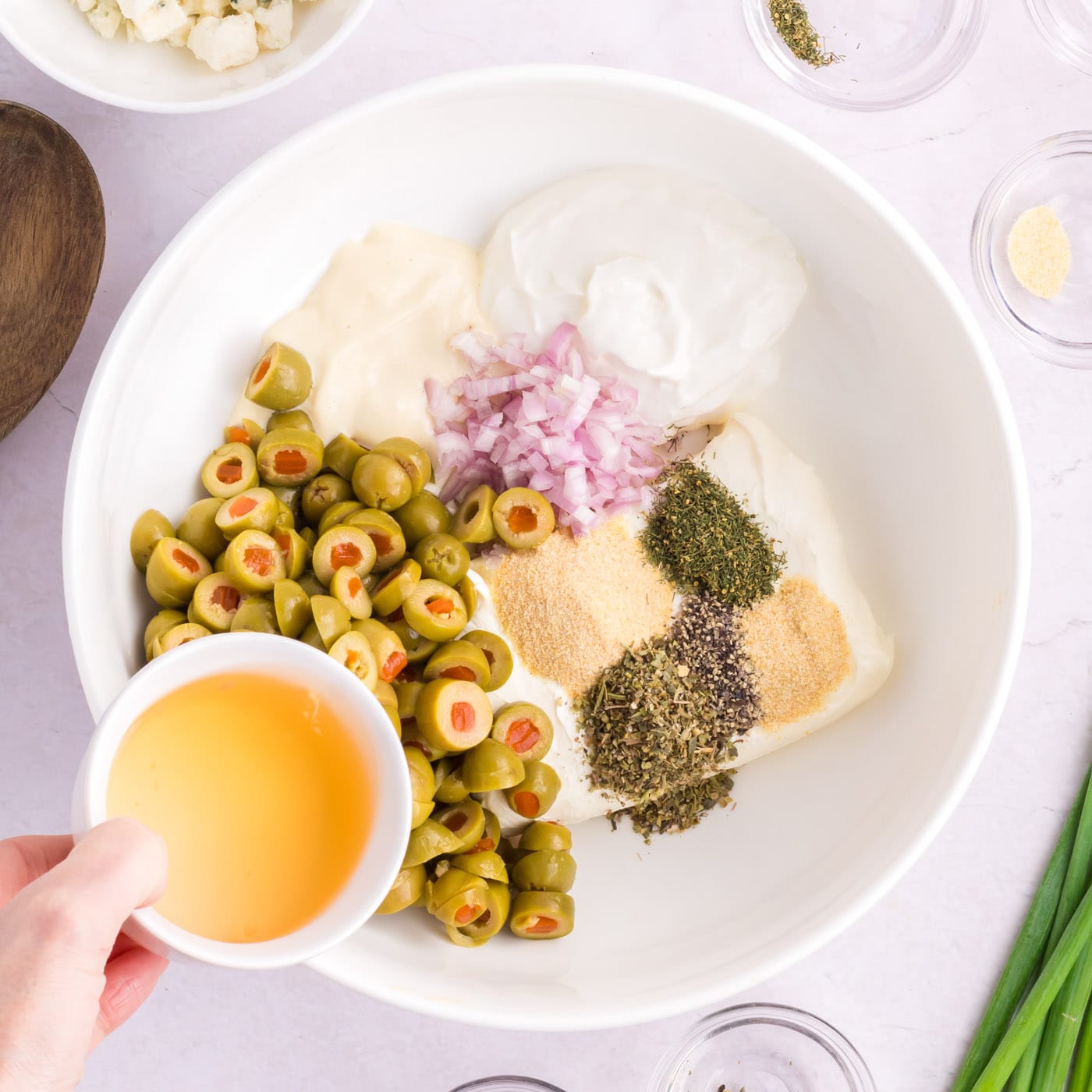 adding olive bring to sliced olives, seasonings, shallot, and cream cheese in a bowl