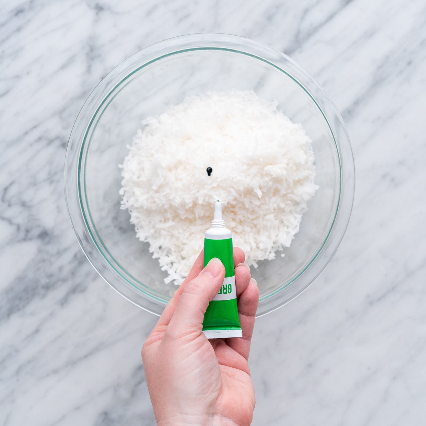adding green gel food color to shredded coconut