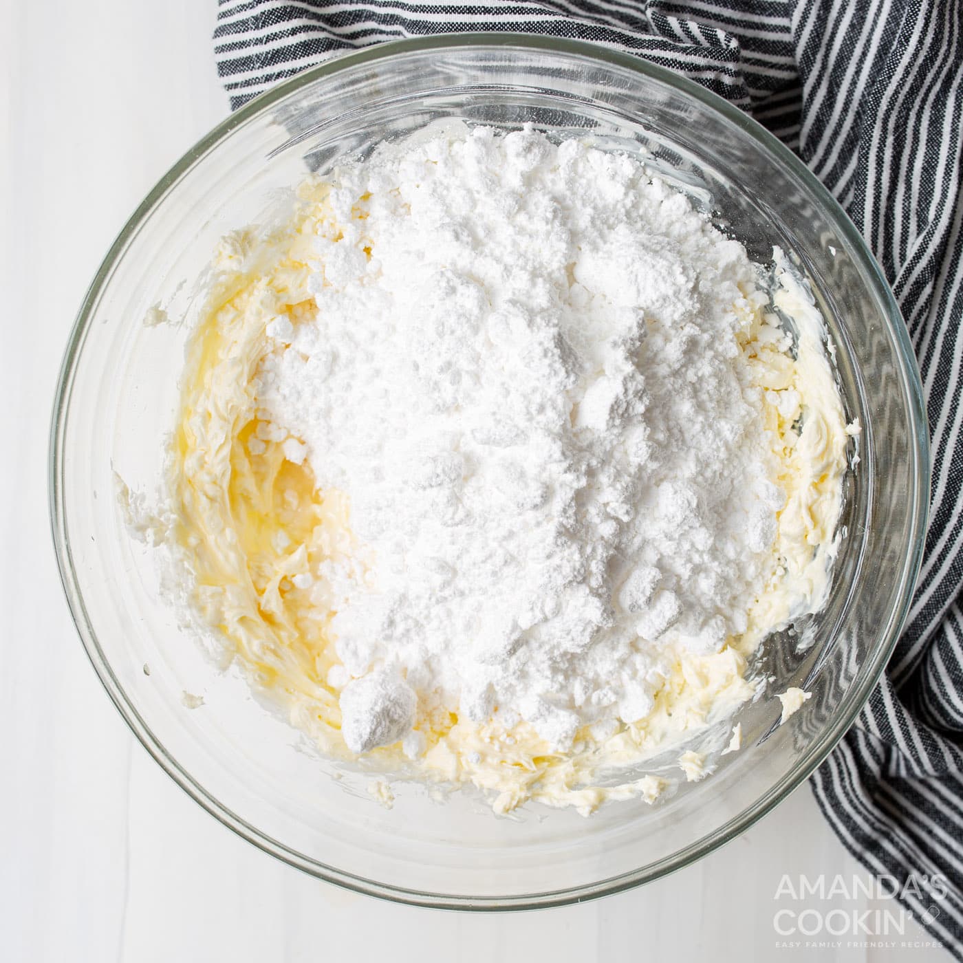 cream cheese and butter with powdered sugar in a bowl