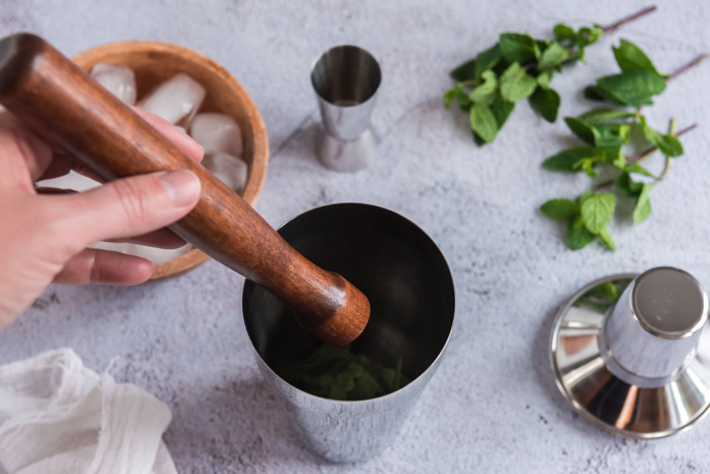 muddling mint in cocktail shaker