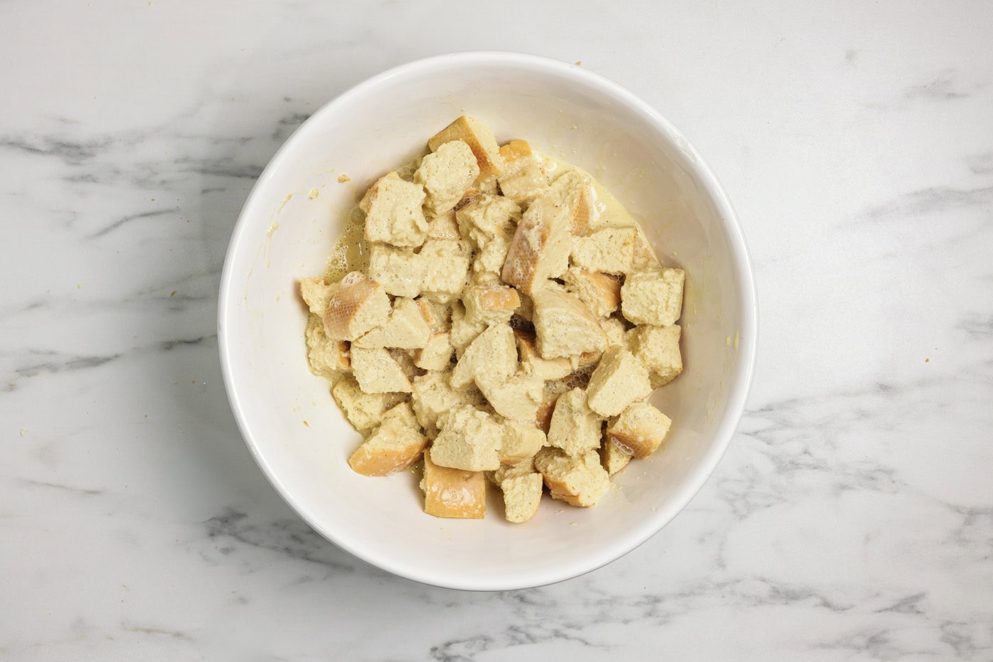 cubed bread in a bowl with custard filling