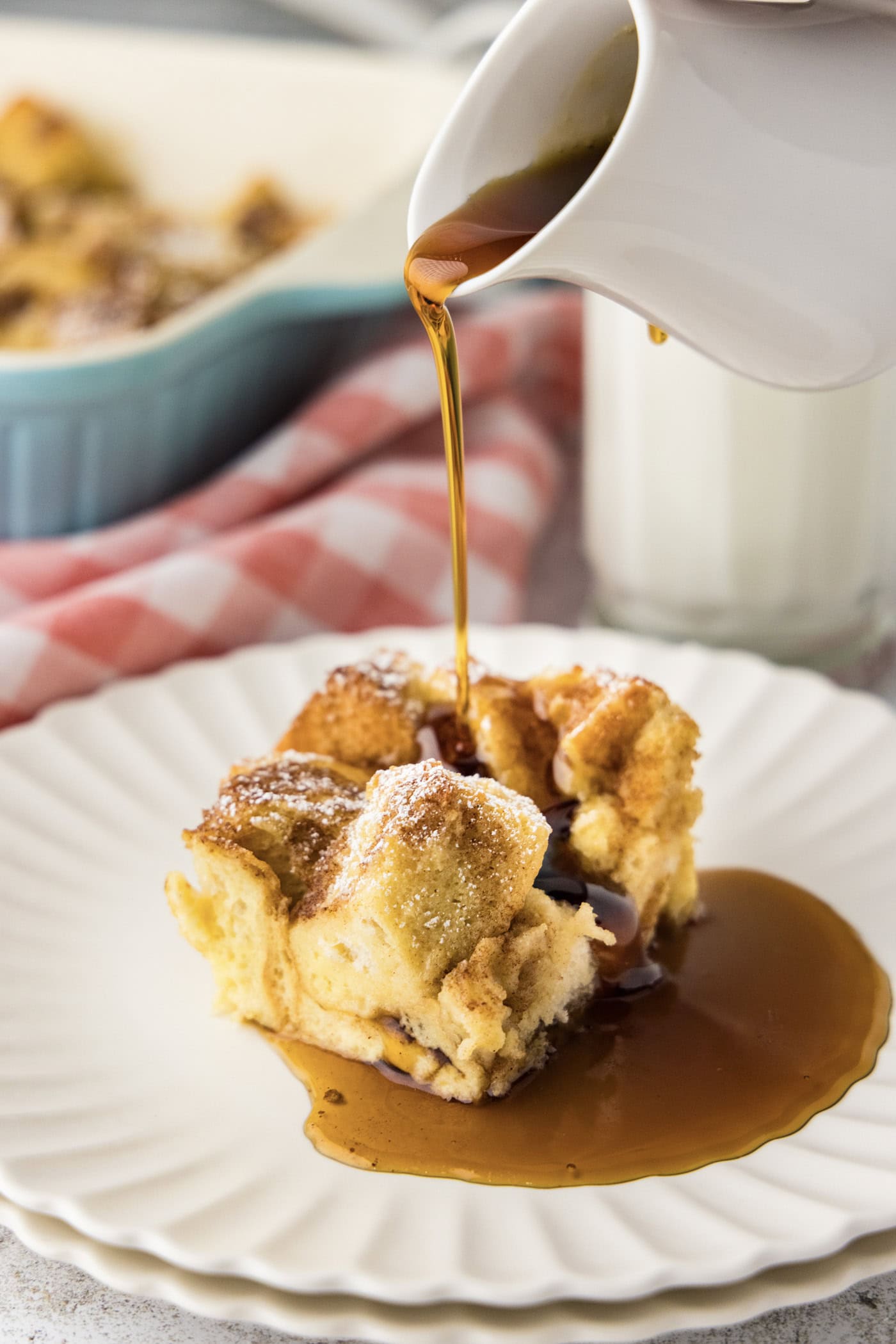 Syrup being poured over a slice of overnight french toast bake