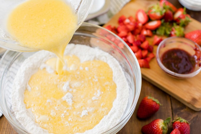 adding wet ingredients to dry ingredients in bowl