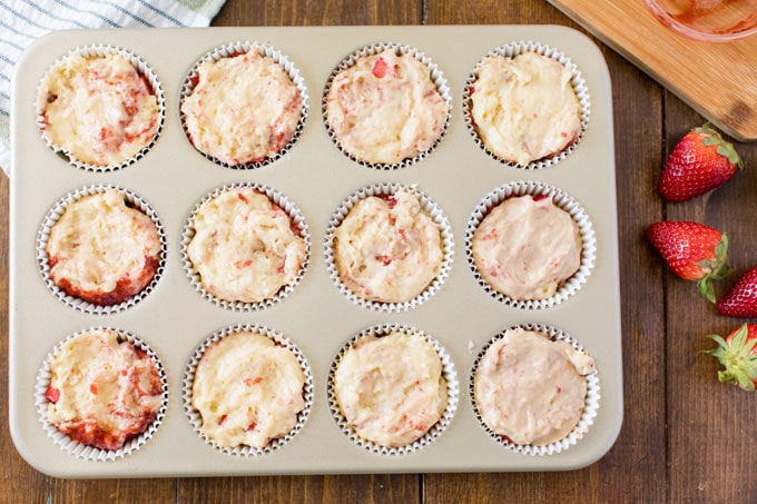 muffin tin with strawberry muffin batter