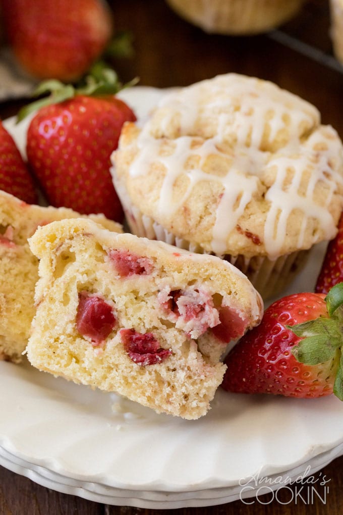 muffin on a plate cut in half showing strawberries inside