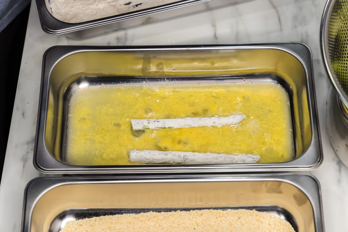 dipping asparagus spears into egg
