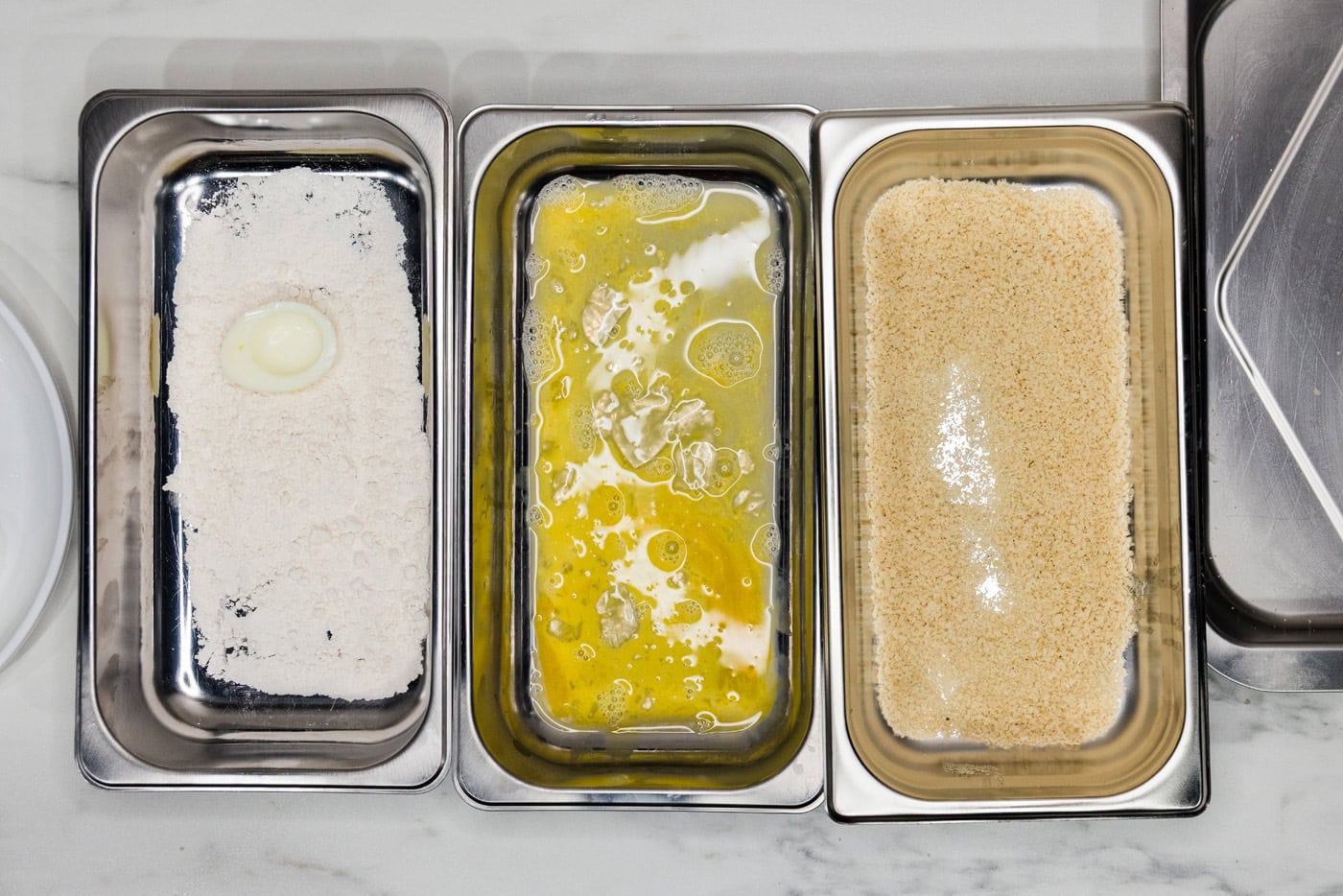 boiled egg in flour inside a breading tray