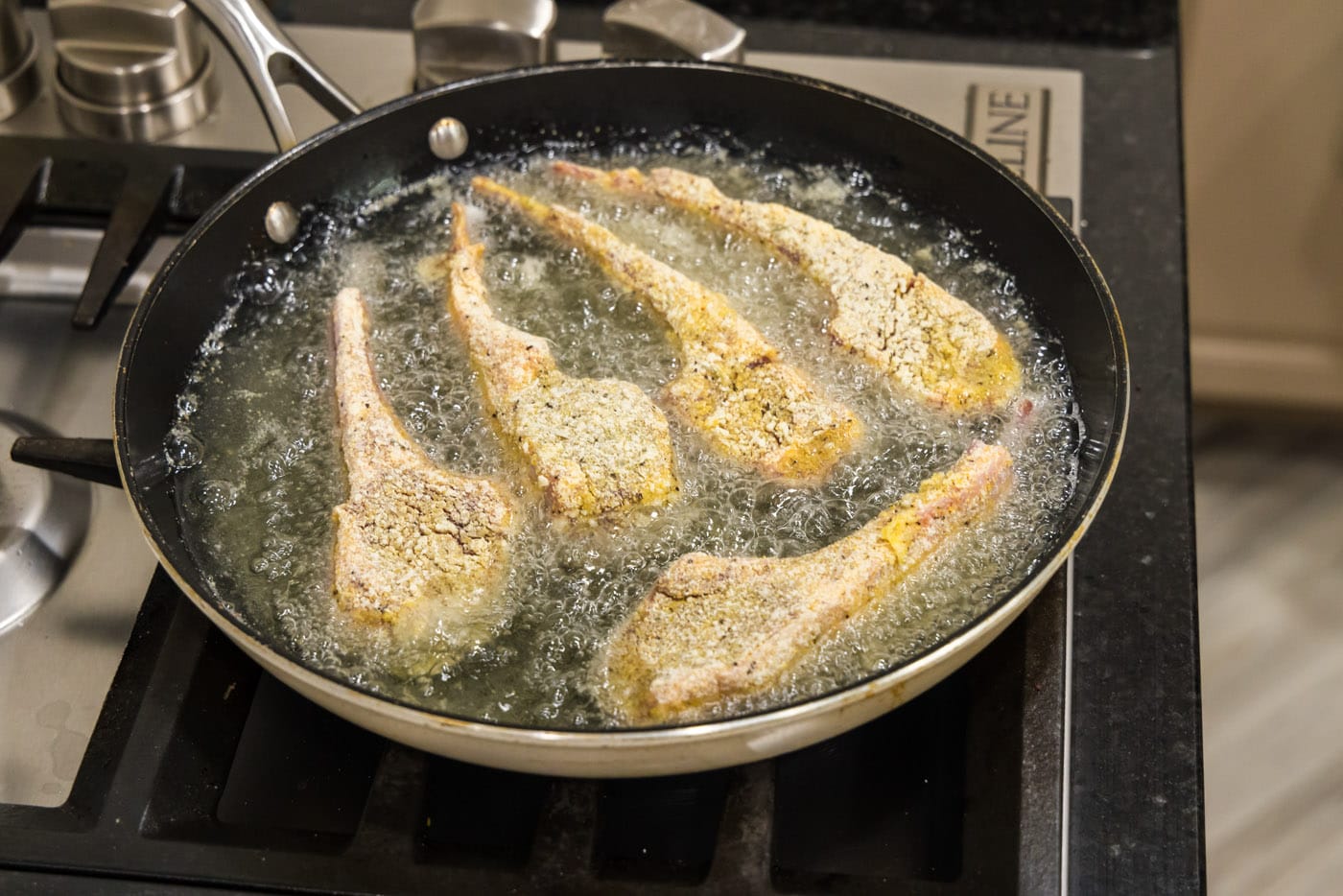 dredged lamb chops frying in oil
