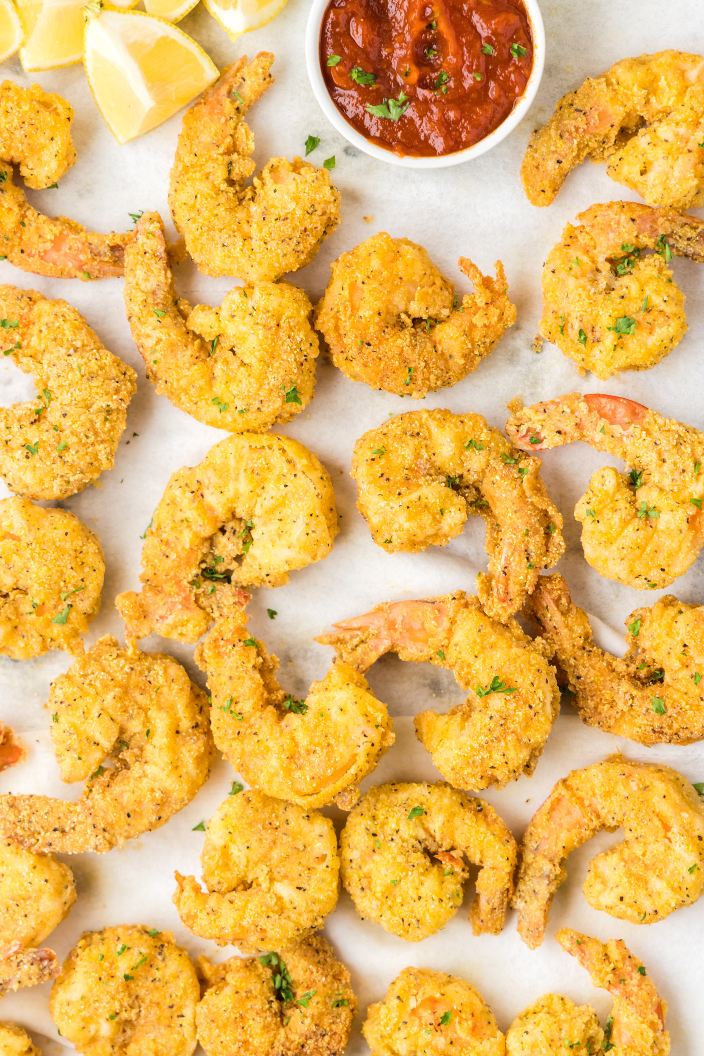 Close up of a pan of Fried Shrimp with a bowl of cocktail sauce