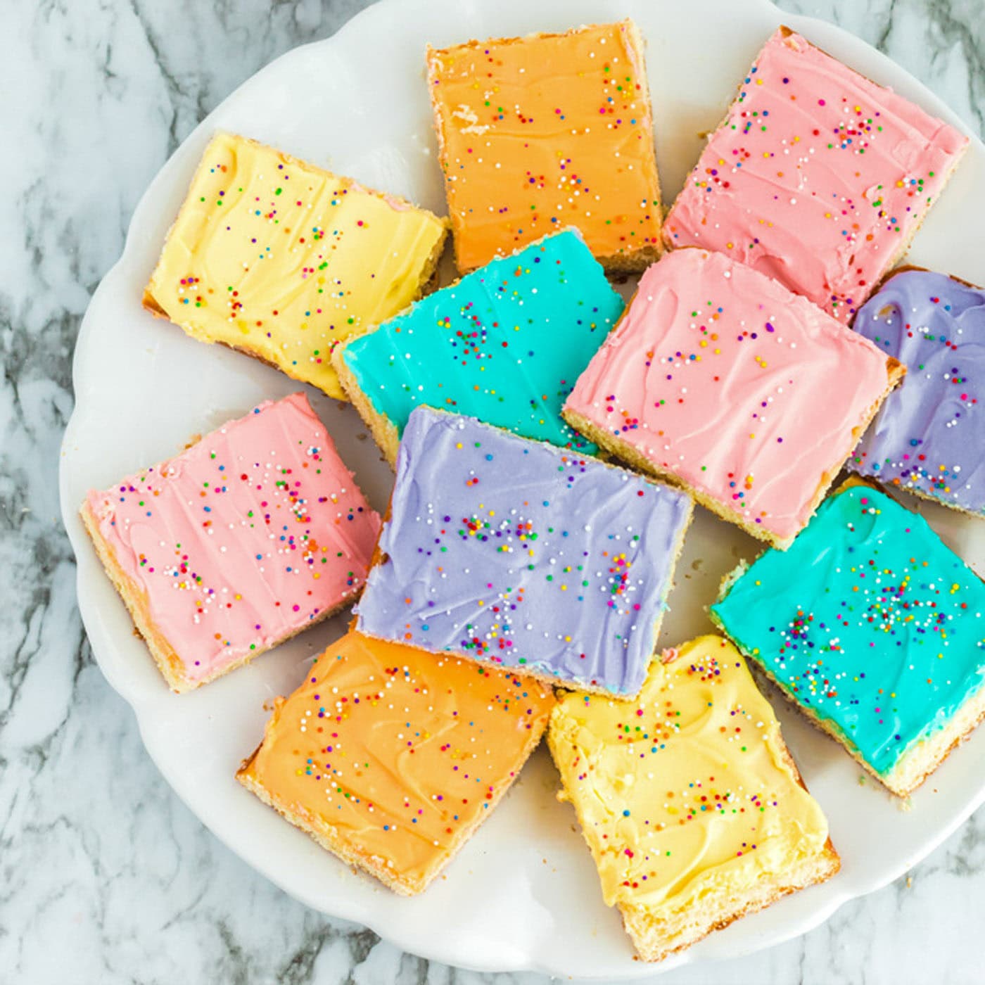 Close up photo of a plate of Frosted Sugar Cookie Bars